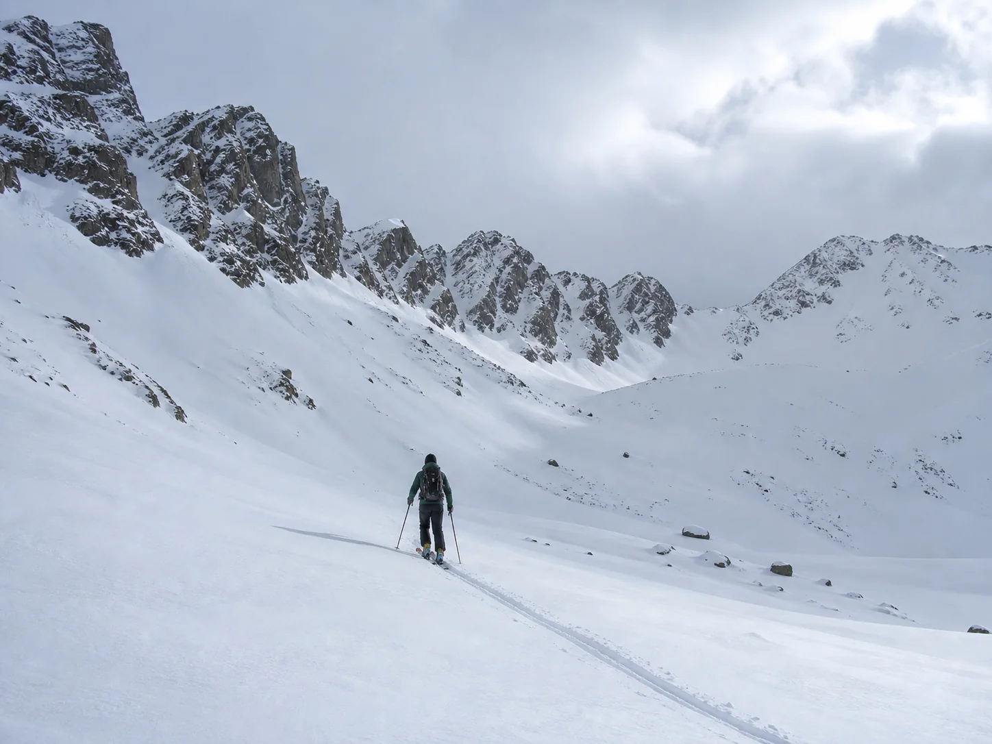Préparation Physique Ski de randonnée et Splitboard durant l'Hiver Skieur de randonnée dans un vallon enneigé